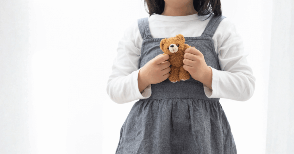 ぬいぐるみを両手で持つ子どもの写真。家庭でのチェックや歯科への相談をやさしく伝える記事内画像。