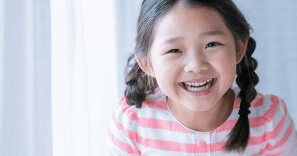 笑顔で歯を見せる子どもの写真。発達特性と歯並びの関係について解説する記事内画像。
